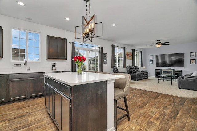 1825 Spencer Way, Shorewood, IL 60404 - kitchen with a sink, a breakfast bar, dark brown cabinetry, light countertops, and dark wood-style floors