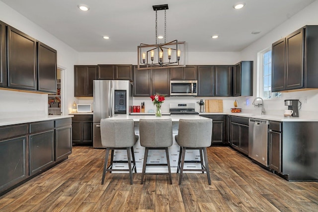 1825 Spencer Way, Shorewood, IL 60404 - kitchen featuring a notable chandelier, light countertops, dark wood-style flooring, a kitchen breakfast bar, and stainless steel appliances