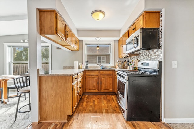 26312 W Blackhawk Ave, Ingleside, IL 60041 - kitchen with brown cabinetry, stainless steel appliances, wood-type flooring, and light countertops