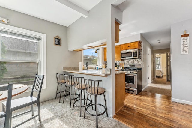 26312 W Blackhawk Ave, Ingleside, IL 60041 - kitchen with light wood-style floors, stainless steel appliances, a healthy amount of sunlight, and brown cabinets