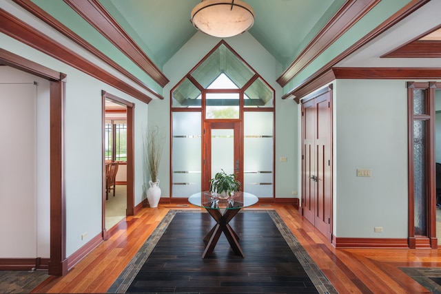 entryway with baseboards, vaulted ceiling, and hardwood / wood-style flooring