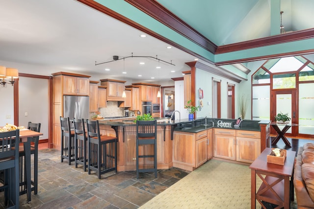 kitchen featuring crown molding, a kitchen bar, tasteful backsplash, vaulted ceiling, and stainless steel appliances