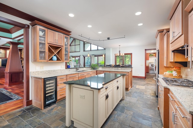 kitchen featuring beverage cooler, recessed lighting, a peninsula, glass insert cabinets, and stone tile flooring