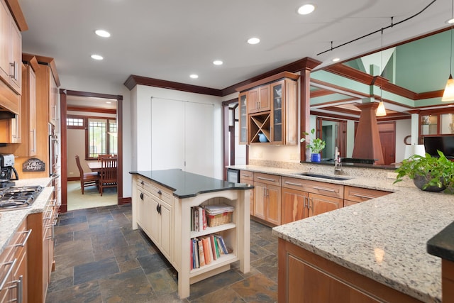 kitchen featuring light stone countertops, a sink, stone tile flooring, glass insert cabinets, and stainless steel appliances