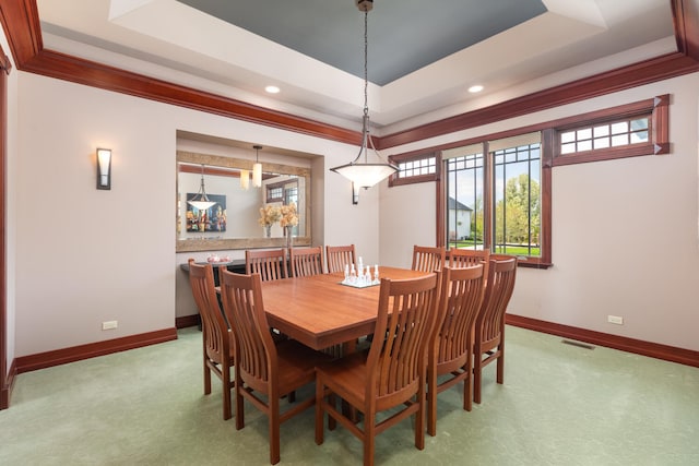 dining space with a raised ceiling, baseboards, and carpet floors