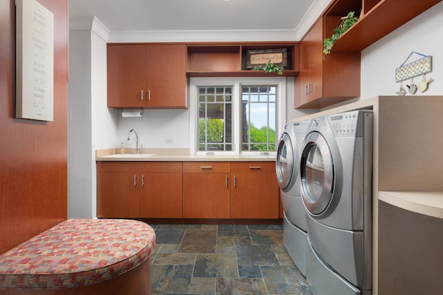 laundry room with a sink, cabinet space, washer and dryer, and stone finish floor