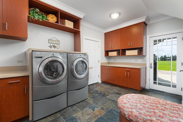 clothes washing area featuring crown molding, stone tile flooring, cabinet space, and washer and dryer