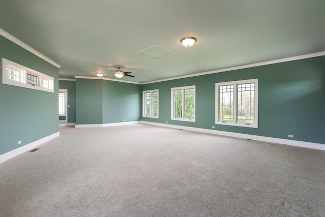 unfurnished room featuring crown molding, carpet, baseboards, and attic access