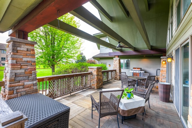 wooden terrace featuring outdoor dining area and ceiling fan