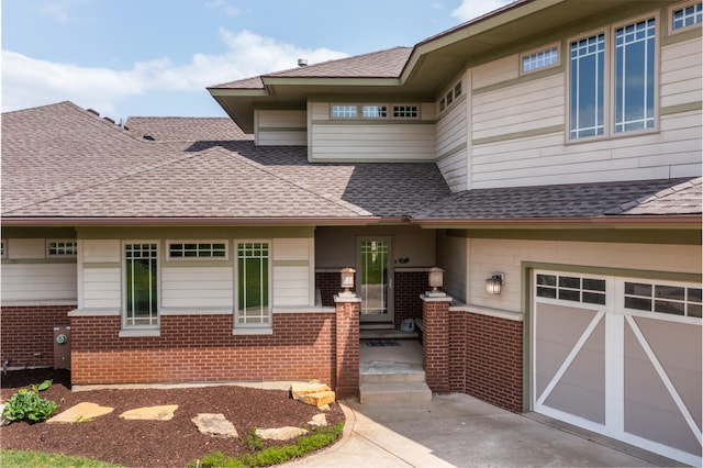 view of front of property with brick siding, a shingled roof, an attached garage, and concrete driveway