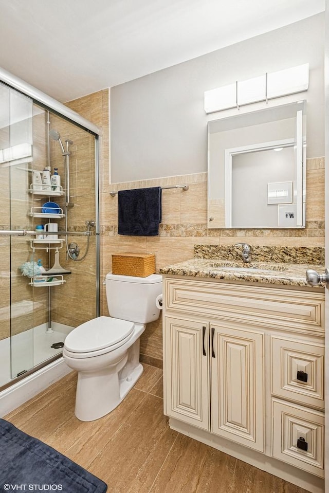 901 S Plymouth Ct Unit 104, Chicago, IL 60605 - bathroom with toilet, a shower stall, wood finished floors, tile walls, and vanity