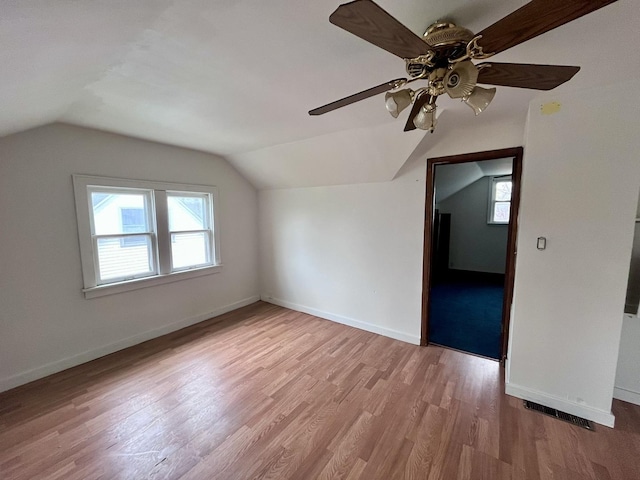 bonus room featuring baseboards, ceiling fan, wood finished floors, and vaulted ceiling