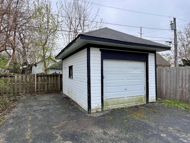detached garage featuring fence