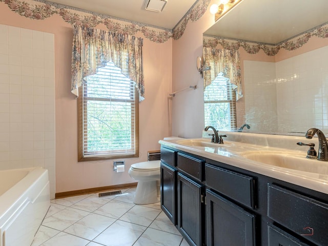 bathroom with toilet, double vanity, and baseboards