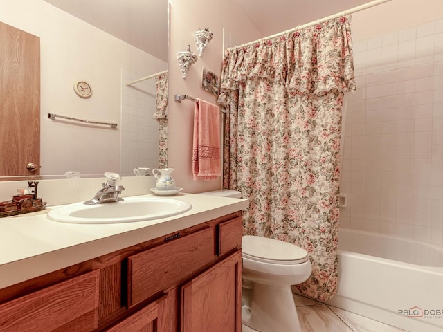 bathroom featuring toilet, shower / bath combo with shower curtain, and vanity
