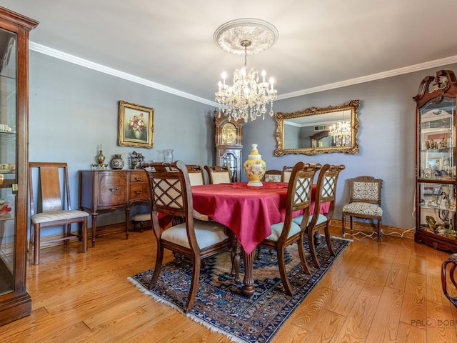 dining room featuring a chandelier, hardwood / wood-style floors, and crown molding