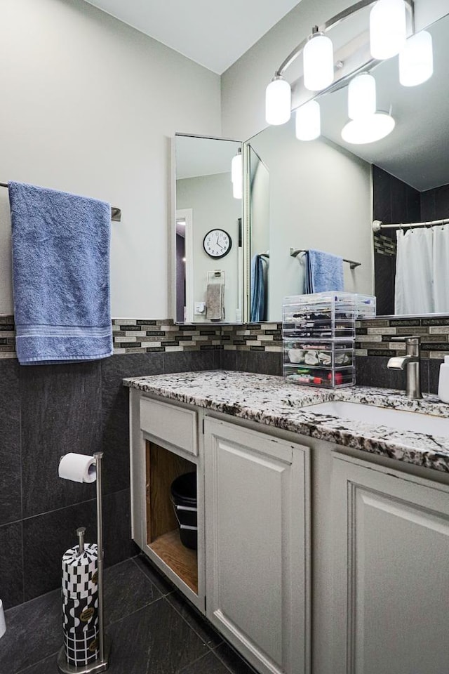 bathroom with vanity, backsplash, granite finish floor, and a shower with shower curtain