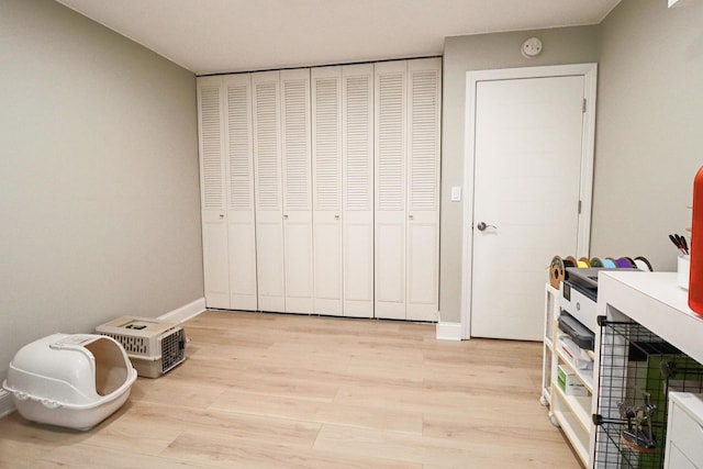 interior space featuring baseboards and light wood finished floors