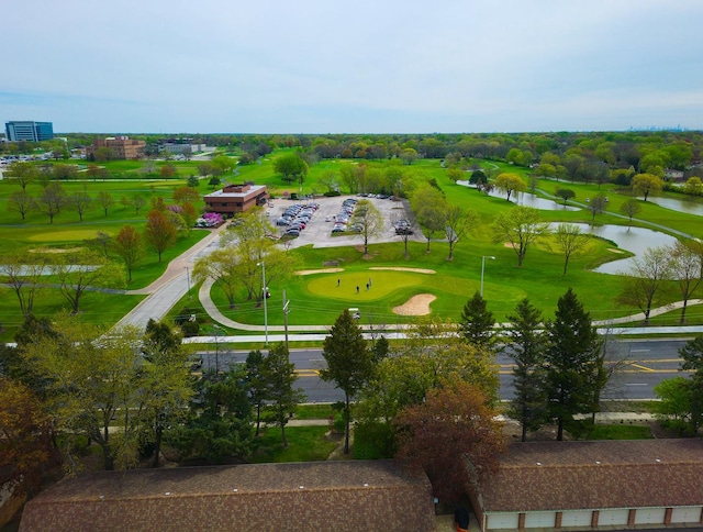 drone / aerial view with a water view and golf course view