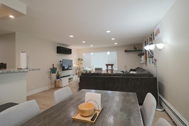 dining room featuring recessed lighting, light wood-style floors, baseboards, and a baseboard radiator