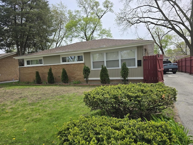3109 Sussex Ave, Markham, IL 60428 - ranch-style house with a front lawn, aphalt driveway, fence, brick siding, and a shingled roof
