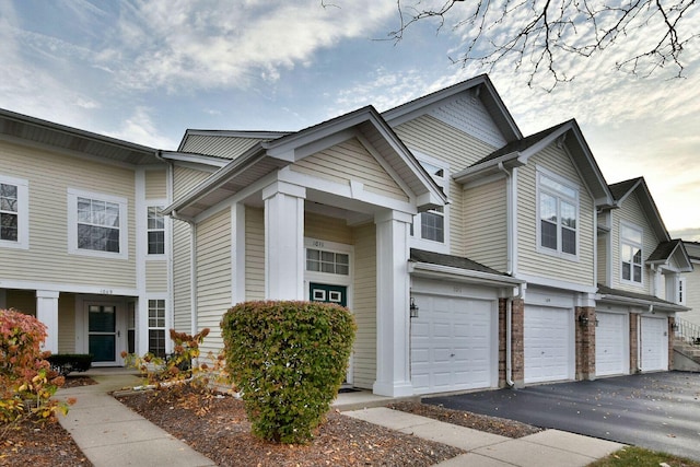 multi unit property featuring a garage and driveway