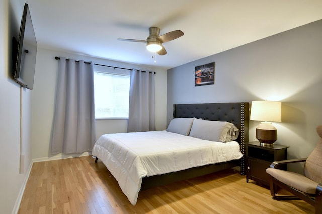 bedroom with baseboards, a ceiling fan, and light wood-style flooring