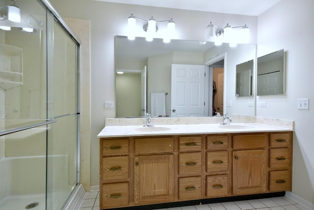 full bath with double vanity, tile patterned floors, a shower stall, and a sink
