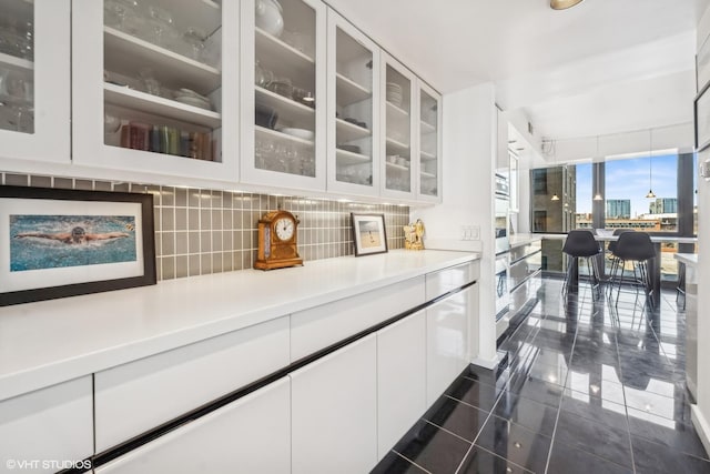 2314 N Lincoln Park W Unit 8-9S, Chicago, IL 60614 - kitchen featuring glass insert cabinets, a wall of windows, light countertops, white cabinets, and tasteful backsplash