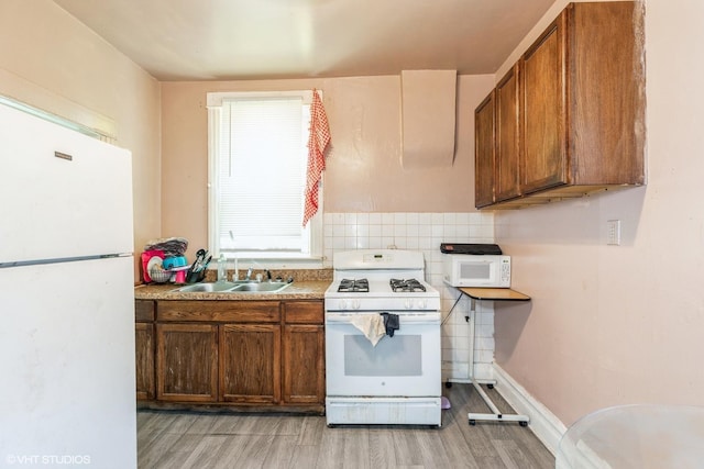 7422 S Kimbark Ave, Chicago, IL 60619 - kitchen with white appliances, a sink, light wood-type flooring, light countertops, and brown cabinetry