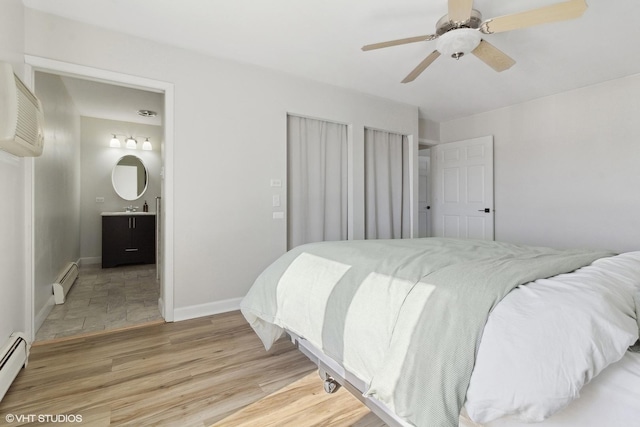 4250 Saratoga Ave Unit 301, Downers Grove, IL 60515 - bedroom with baseboards, baseboard heating, light wood finished floors, and ensuite bath