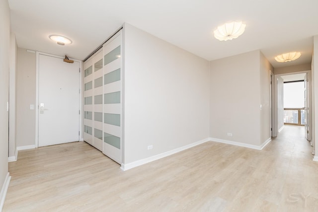 empty room with light wood-style floors and baseboards