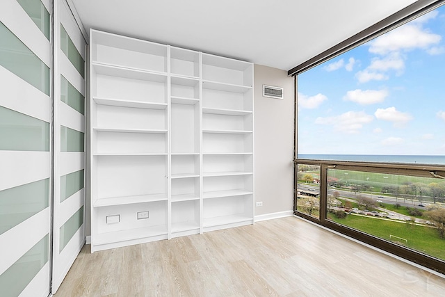 balcony featuring a water view and visible vents