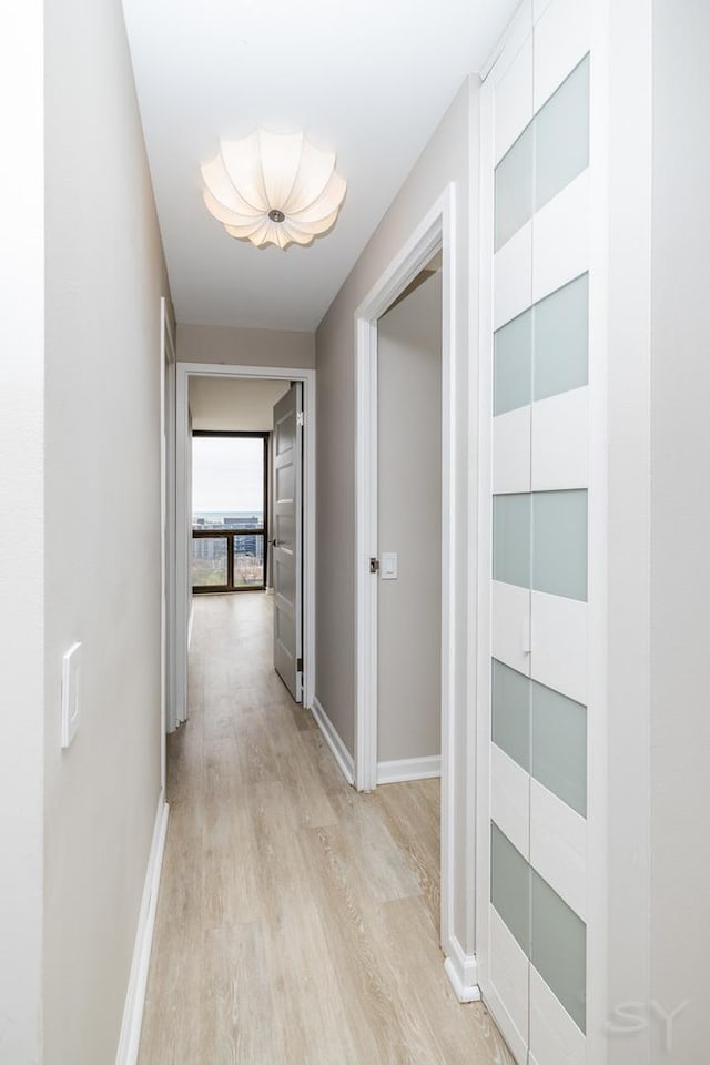 hallway with baseboards and light wood-type flooring