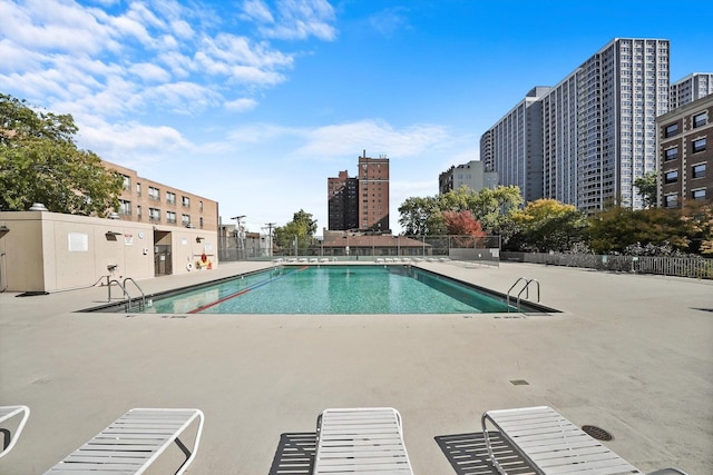 pool with fence and a patio area