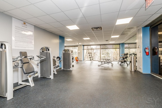 exercise room with a drop ceiling and visible vents
