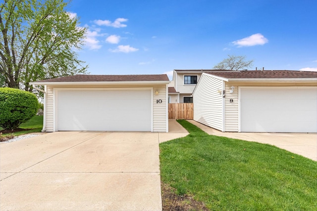 view of front facade with fence, a front yard, and a garage