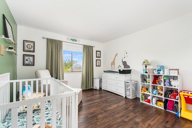 bedroom with a crib and wood finished floors