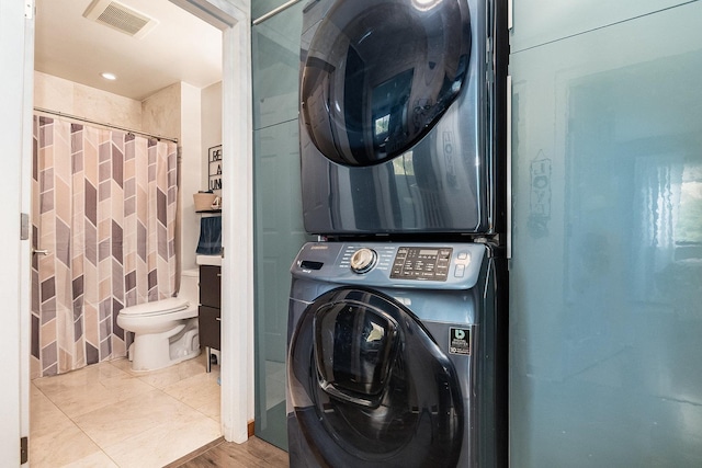 laundry area featuring laundry area, visible vents, and stacked washer / dryer