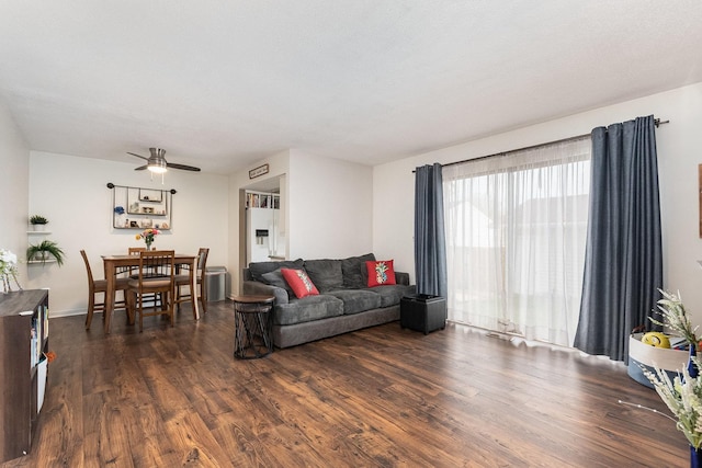 living room featuring a ceiling fan and dark wood-style flooring