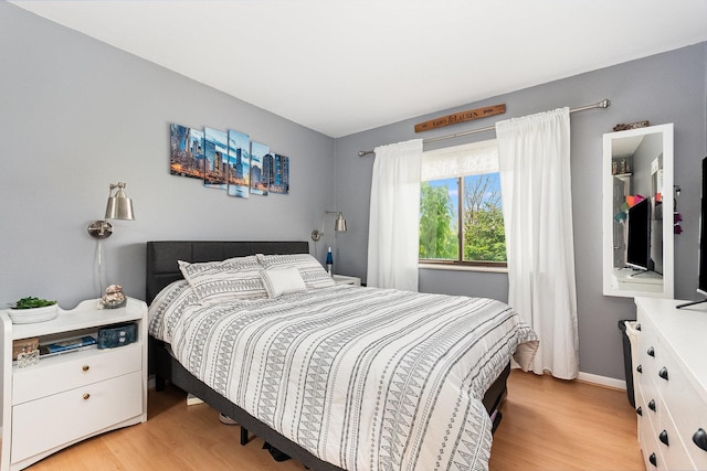 bedroom featuring baseboards and light wood finished floors