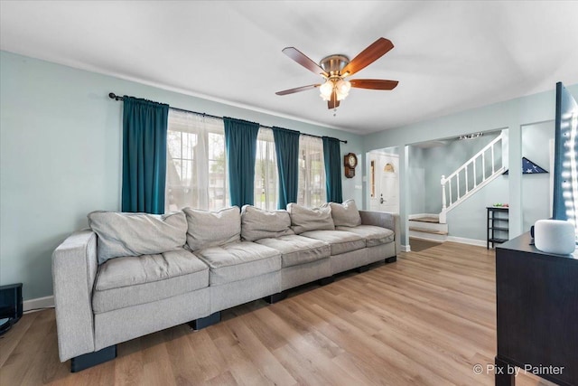 8015 S Carrolton Ct, Hanover Park, IL 60133 - living area featuring light wood-style floors, baseboards, a ceiling fan, and stairs