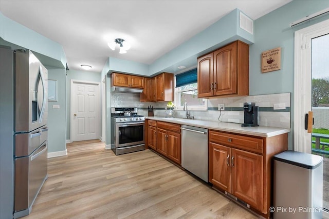 8015 S Carrolton Ct, Hanover Park, IL 60133 - kitchen with under cabinet range hood, stainless steel appliances, brown cabinets, and a sink