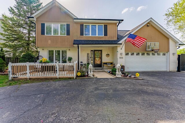 view of front of house featuring a garage, driveway, roof with shingles, and brick siding