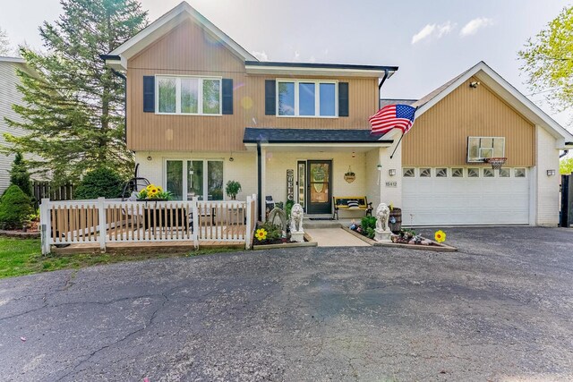 view of front of property featuring brick siding, driveway, and a garage