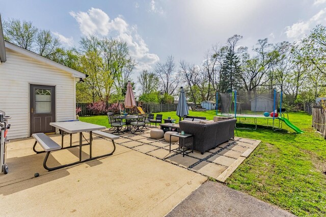 view of patio with a fenced backyard, outdoor dining space, and a trampoline