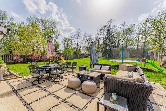 view of patio with outdoor dining area, a trampoline, a fenced backyard, a playground, and outdoor lounge area