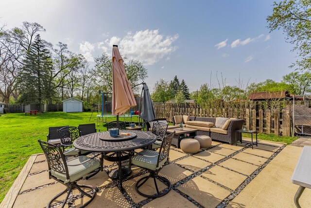 view of patio / terrace featuring an outdoor living space, a storage shed, an outbuilding, a fenced backyard, and outdoor dining space