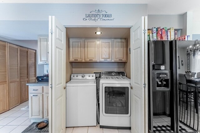 laundry area with light tile patterned floors, cabinet space, and washer and dryer