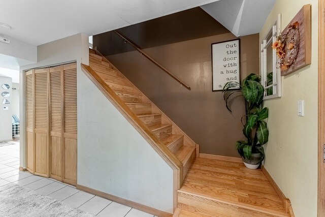 staircase featuring baseboards and wood finished floors